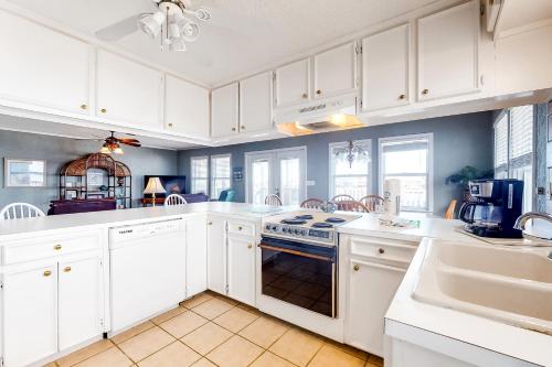 a kitchen with white cabinets and a stove top oven at Bay Dream Believer in Dauphin Island