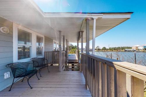 a porch of a house with chairs and a view of the water at Bay Dream Believer in Dauphin Island