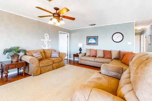 a living room with couches and a ceiling fan at Bay Dream Believer in Dauphin Island