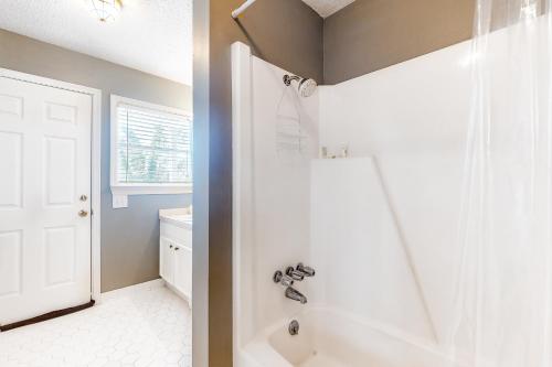 a bathroom with a white tub and a sink at Bay Dream Believer in Dauphin Island