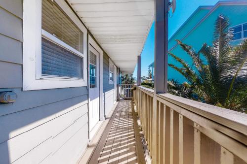 a porch of a blue house with a window at Bay Dream Believer in Dauphin Island