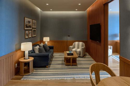 a living room with a couch and a tv at Boa Vista Surf Lodge in Pôrto Feliz