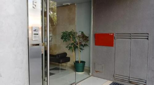 una puerta de cristal con una silla y una planta en Armónico en Bs As, en Buenos Aires