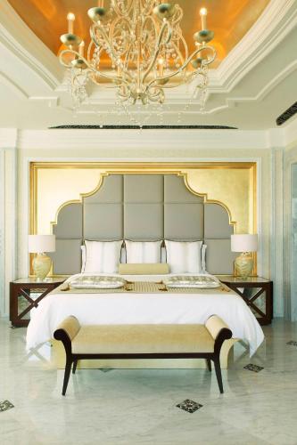 a bedroom with a large bed and a chandelier at The St. Regis Abu Dhabi in Abu Dhabi