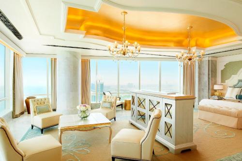 a living room with a bed and a table and chairs at The St. Regis Abu Dhabi in Abu Dhabi