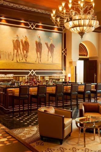 a bar with a large painting of camel riders at The St. Regis Abu Dhabi in Abu Dhabi