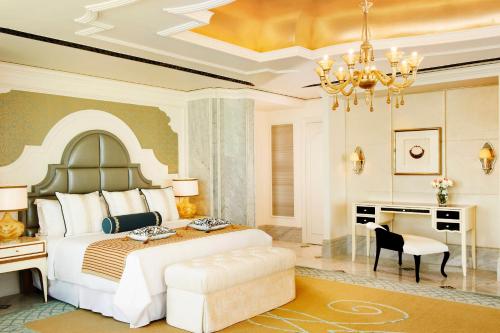 a bedroom with a bed and a desk and a chandelier at The St. Regis Abu Dhabi in Abu Dhabi