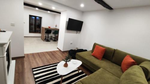 a living room with a couch and a table at Вивиан - модерна вила за гости in Reselets