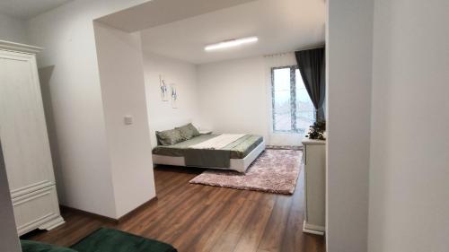 a bedroom with a bed in a white room at Вивиан - модерна вила за гости in Reselets