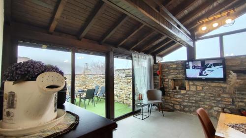 a living room with a large window and a tv at Вивиан - модерна вила за гости in Reselets