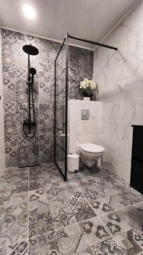 a bathroom with a shower and a toilet at Вивиан - модерна вила за гости in Reselets