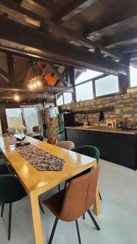 a dining room with a wooden table and chairs at Вивиан - модерна вила за гости in Reselets