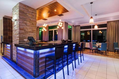 a kitchen with a bar with blue stools at Protea Hotel by Marriott Lusaka in Lusaka