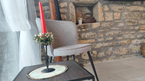 a chair and a vase on a table with a candle at Вивиан - модерна вила за гости in Reselets