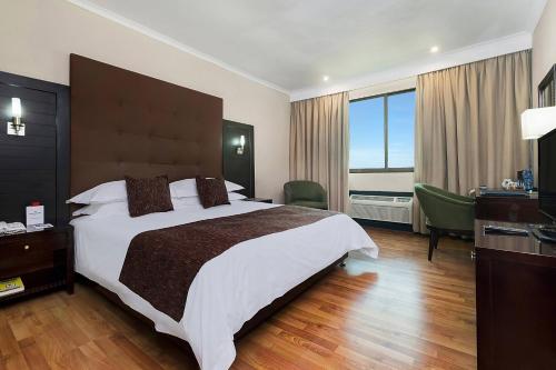 a bedroom with a large bed and a large window at Protea Hotel by Marriott Lusaka in Lusaka