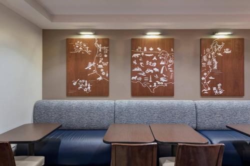 a waiting room with a blue couch and two tables at TownePlace Suites by Marriott Monroe in Monroe