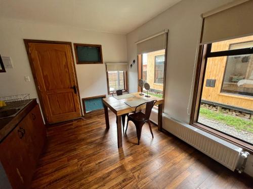 Habitación con mesa de madera y ventana. en Kayu Loft, en Puerto Natales