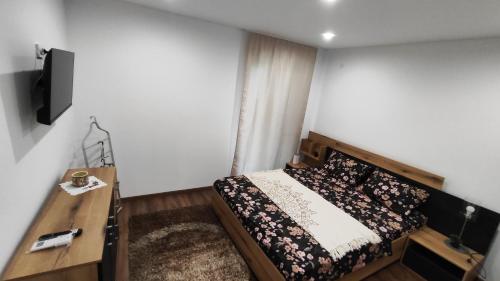 a bedroom with a bed and a tv on a wall at Вивиан - модерна вила за гости in Reselets