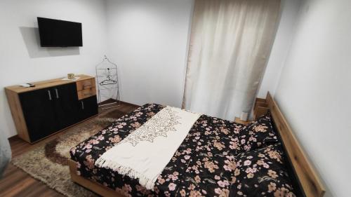 a bedroom with a bed and a dresser and a television at Вивиан - модерна вила за гости in Reselets