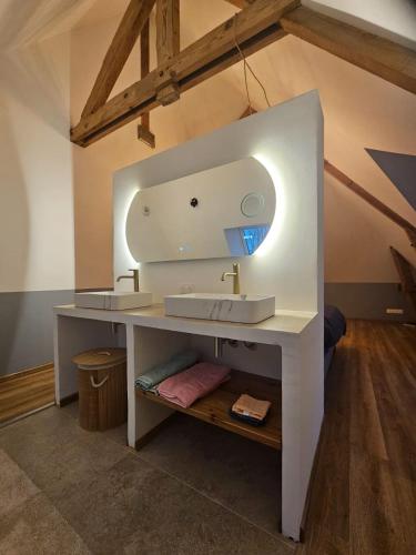 une salle de bain avec un lavabo blanc et un miroir dans l'établissement Domaine Caloin - SPA, à Echinghen