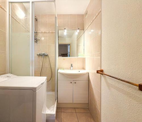 une salle de bain blanche avec une douche et un lavabo dans l'établissement L Eden Croisette nid douillet en bord de plage, à La Londe-les-Maures