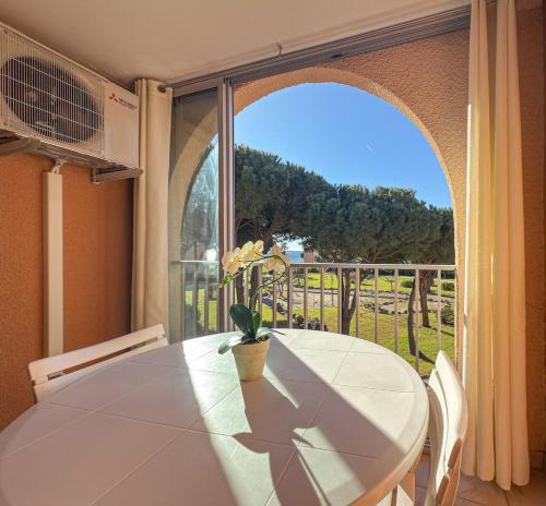 une salle à manger avec une table et une grande fenêtre dans l'établissement L Eden Croisette nid douillet en bord de plage, à La Londe-les-Maures