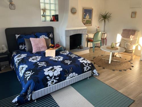 - une chambre avec un lit doté d'une couette bleue et d'une cheminée dans l'établissement Studio avec terrasse charmante à -10mn du métro 4, à Bagneux