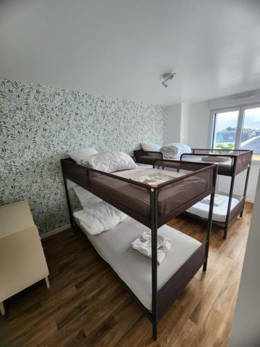 une chambre avec trois lits superposés dans l'établissement Ti an holen Maison familiale de charme à 5mn à pied de la plage et du port, à Ploudalmézeau