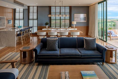 a living room with a blue couch and a kitchen at Boa Vista Surf Lodge in Pôrto Feliz