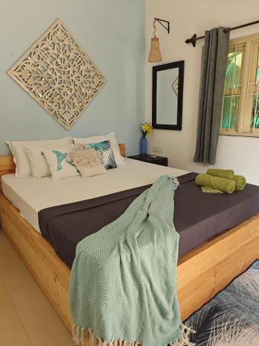 a bedroom with a large bed with a blanket on it at SOLS Backyard in Arambol