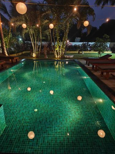 a swimming pool with green tiled floors and lights at SOLS Backyard in Arambol