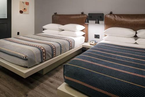two beds sitting next to each other in a room at Moxy Nashville Vanderbilt Area in Nashville