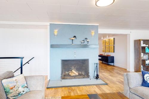 a living room with a blue wall with a fireplace at Oceanside Skies - Main House in Oceanside