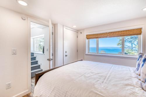 a bedroom with a bed with a view of the ocean at Oceanside Skies - Main House in Oceanside