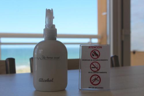 a bottle of alcohol next to a sign on a table at La hora azul departamentos in Playas Doradas