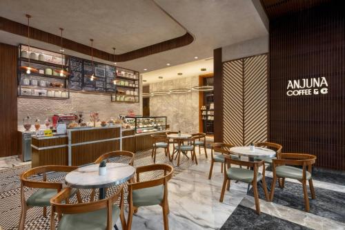 a restaurant with tables and chairs and a counter at The Westin Goa in Vagator