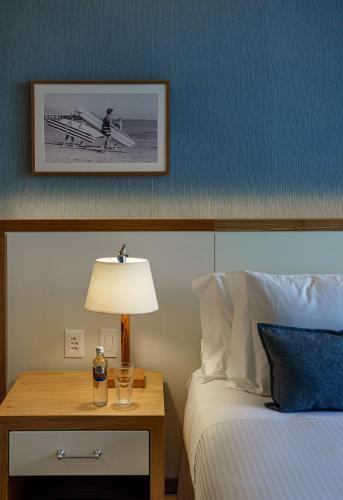 a bedroom with a bed and a table with a lamp at Boa Vista Surf Lodge in Pôrto Feliz