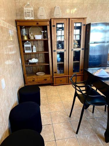 a room with a table and chairs and a cabinet at Casa da Lagoa in Tramandaí