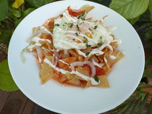 a white plate of food with nachos and coleslaw at Mexhe Hotel El Cuyo in El Cuyo