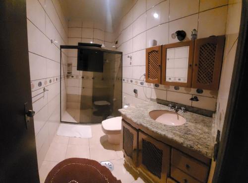 ein Badezimmer mit Waschbecken, Dusche und Toilette in der Unterkunft Casa para Réveillon na praia in São Sebastião