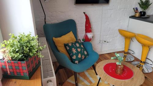 a living room with a blue chair and a table at apartament w centrum miasta in Bydgoszcz