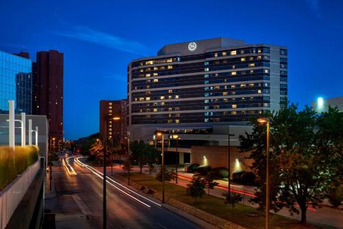 a tall building in a city at night with street lights at Sheraton Inner Harbor Hotel in Baltimore