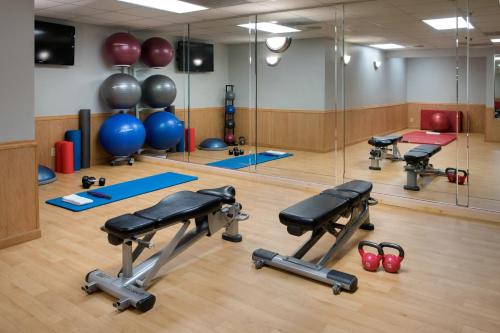 a gym with a row of exercise equipment and mirrors at Sheraton Inner Harbor Hotel in Baltimore