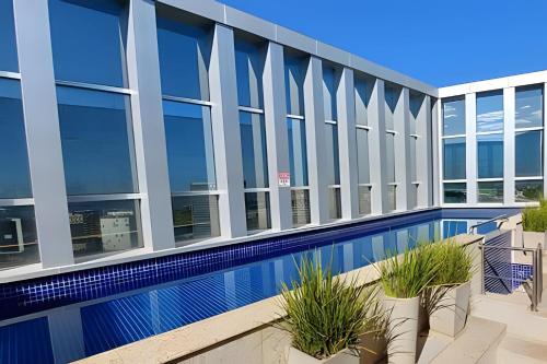 巴西利亚Vision, local nota 10! Academia, sauna e piscinas.的一座带游泳池的建筑的图象