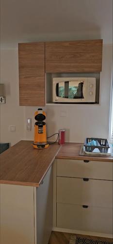 une petite cuisine avec un four micro-ondes au-dessus d'un comptoir dans l'établissement mobil home grand confort, à Valras-Plage