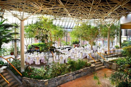 a restaurant with tables and chairs in a greenhouse at Sheraton Hotel Newfoundland in St. John's