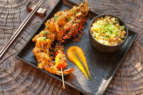 a plate of food with shrimp and a bowl of rice at The Ritz-Carlton Maldives, Fari Islands in North Male Atoll