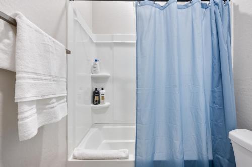 ein Badezimmer mit einem blauen Duschvorhang und einem Waschbecken in der Unterkunft Spacious Two Bedroom Two Bathroom with Free Parking and Cozy Beds in Glendale
