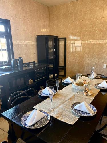 a table with plates and wine glasses on it at Casa da Lagoa in Tramandaí