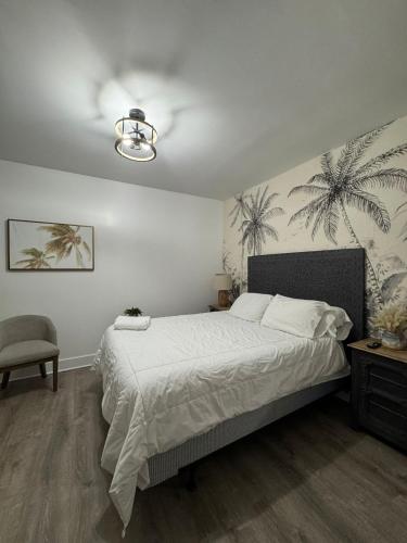 a bedroom with a bed with white sheets and palm trees on the wall at Hotel Rainbow - Miami - Little Havanna in Miami